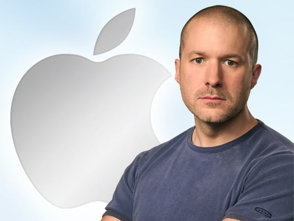 Mężczyzna w granatowej koszulce na tle logo Apple z przyciętym wierzchołkiem loga.