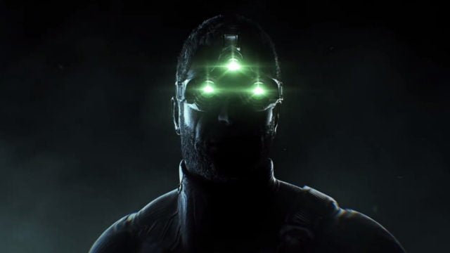 Mężczyzna z brodą w ciemności noszący na głowie urządzenie z trzema zielonymi światłami. To Sam Fisher, postać z gry Splinter Cell Remake
