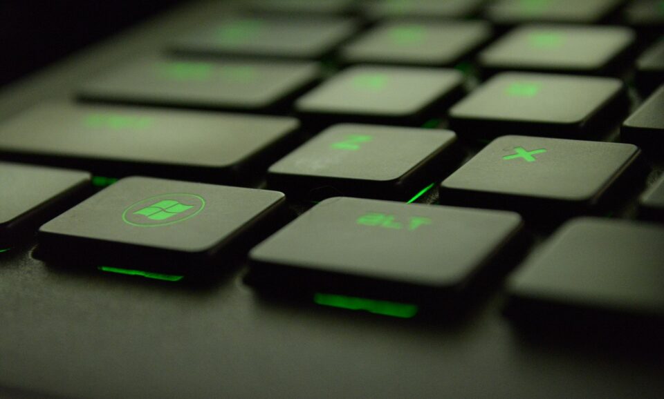 Podświetlana na zielono klawiatura komputerowa, na której wyróżnia się klawisz z logiem systemu Windows.