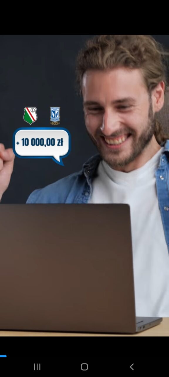 Uśmiechnięty mężczyzna patrzący na laptopa z dymkiem zawierającym tekst "+ 10 000,00 zł" oraz loga dwóch zespołów piłkarskich.