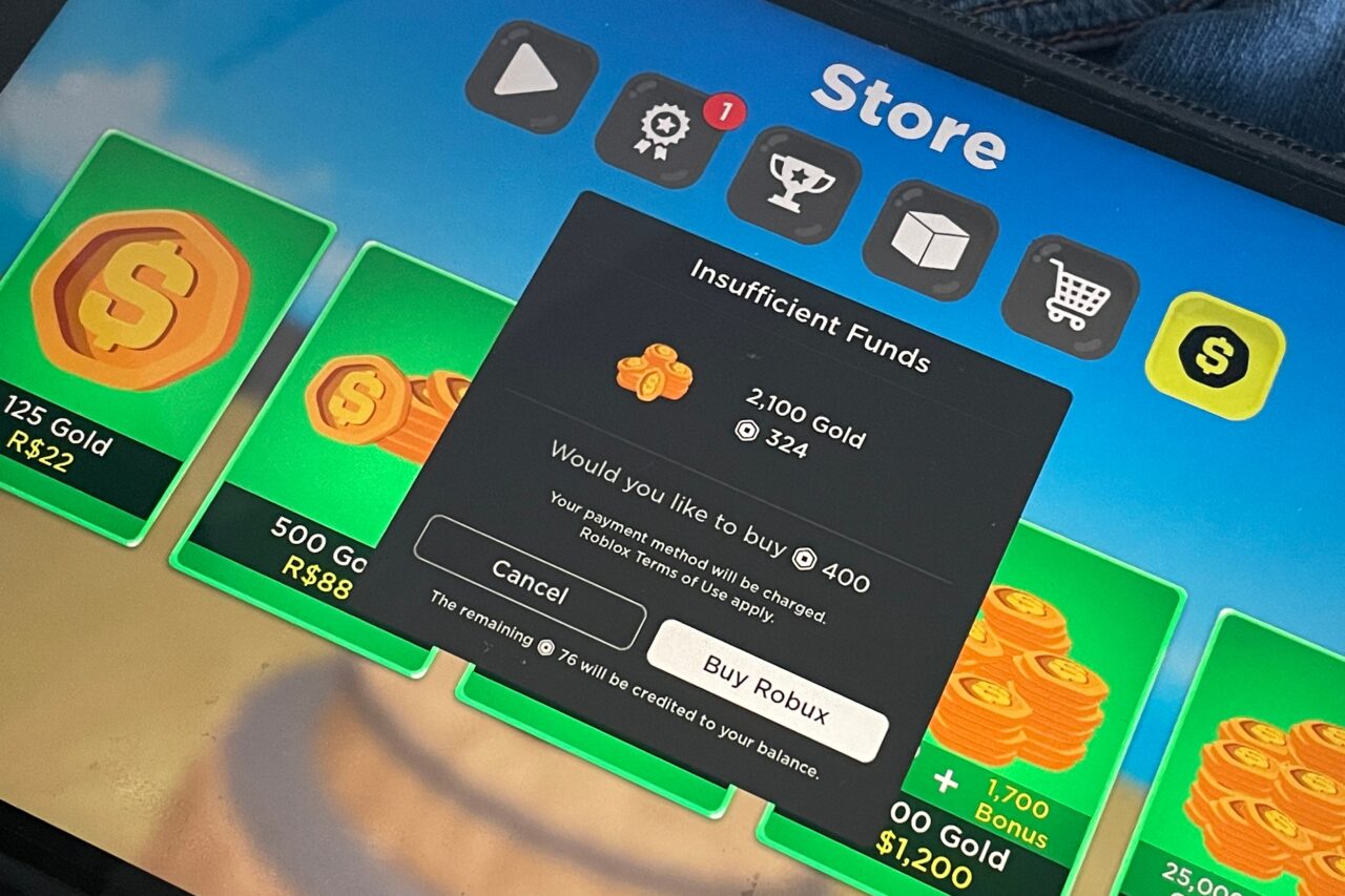 Ekran sklepu w grze z otwartym oknem dialogowym "Insufficient Funds", pokazującym opcje zakupu "2,100 Gold" za 324 Robux oraz przyciski "Cancel" i "Buy Robux".
