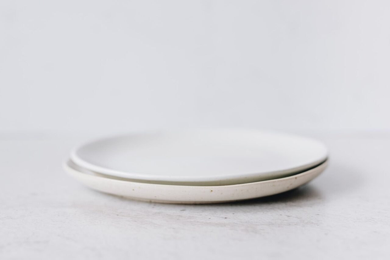 Zdjęcie przedstawia dwa białe talerze, które mogą być pomocne, gdy zadajemy sobie pytanie "Czemu jedna słuchawka gra ciszej"