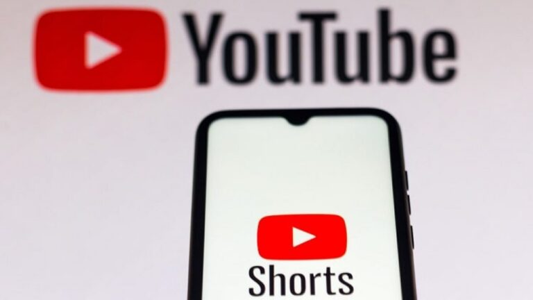 Smartfon z otwartą aplikacją YouTube Shorts, a w tle logo YouTube.