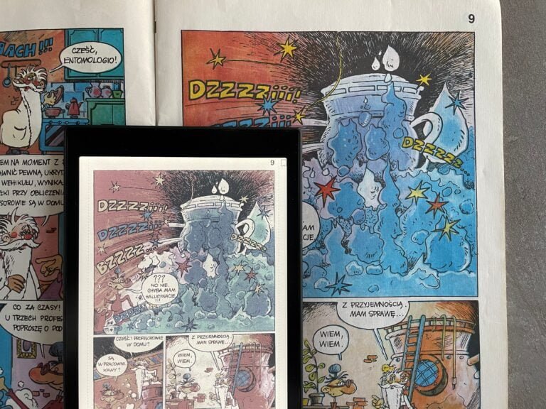 Zdjęcie otwartej książki z komiksem, przedstawiające różne kadry z przygodami postaci komiksowych, gdzie główny motyw to eksplozja i dialogi postaci.