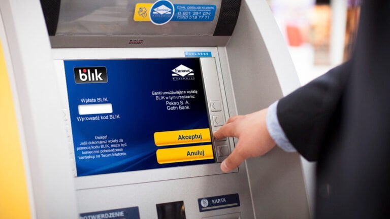 Osoba wpłacająca gotówkę w bankomacie Euronet z wykorzystaniem systemu płatności BLIK. Na ekranie widać opcje "Akceptuj" i "Anuluj".