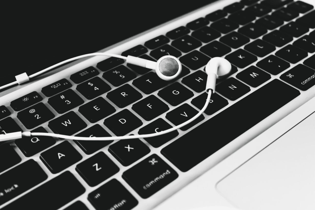 Zdjęcie przedstawia słuchawki douszne na klawiaturze laptopa