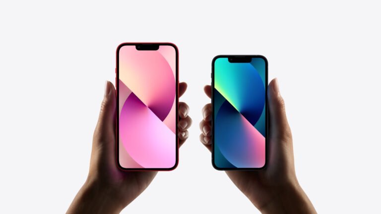 Dwie ręce trzymające nowoczesne smartfony z kolorowymi tapetami na białym tle.