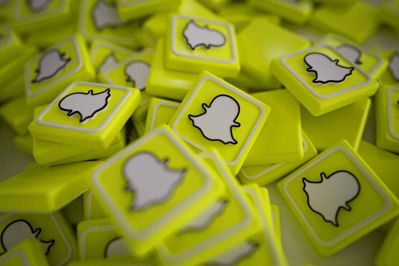 Stos żółtych, plastikowych kostek z czarno-białym logo aplikacji Snapchat na każdej z nich.