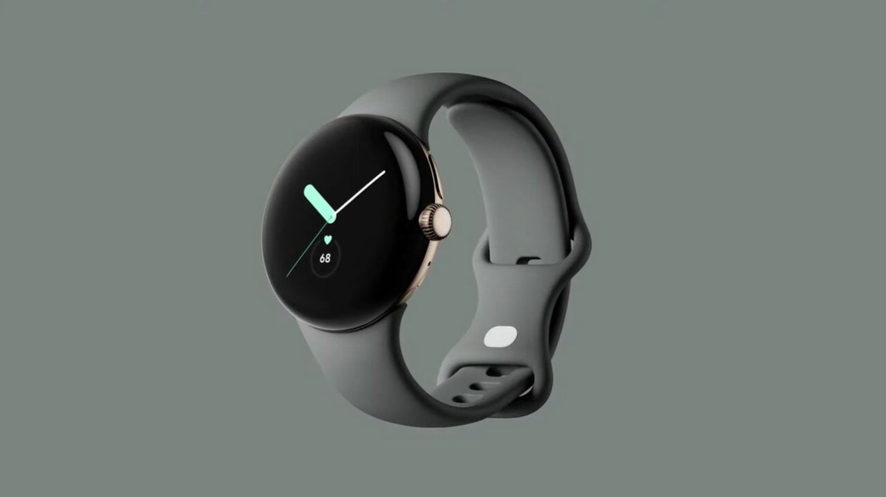 Czarny smartwatch Google Pixel Watch z okrągłą tarczą i cyfrowym wyświetlaczem, pokazującym czas i tętno, na szarym pasku, umieszczony na jednolitym, szarym tle.