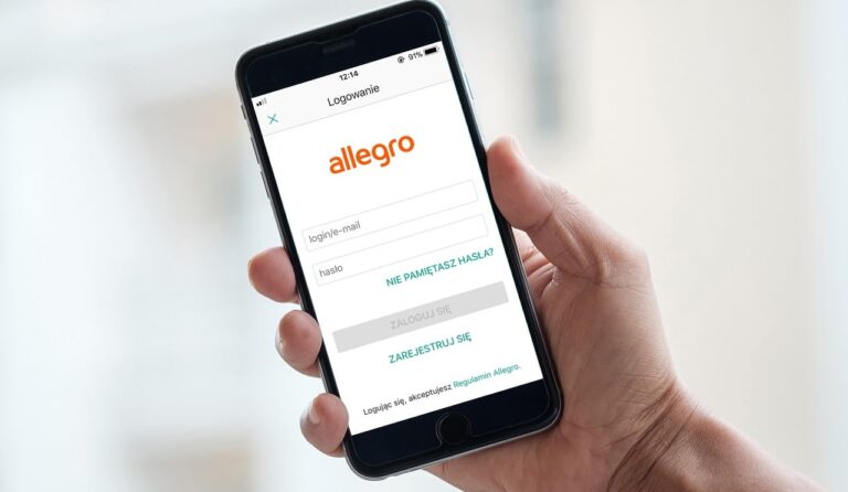 Osoba trzymająca smartfon z ekranem logowania do aplikacji Allegro.