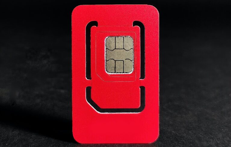 Czerwona karta SIM wyciągnięta ze starteru na ciemnym tle.