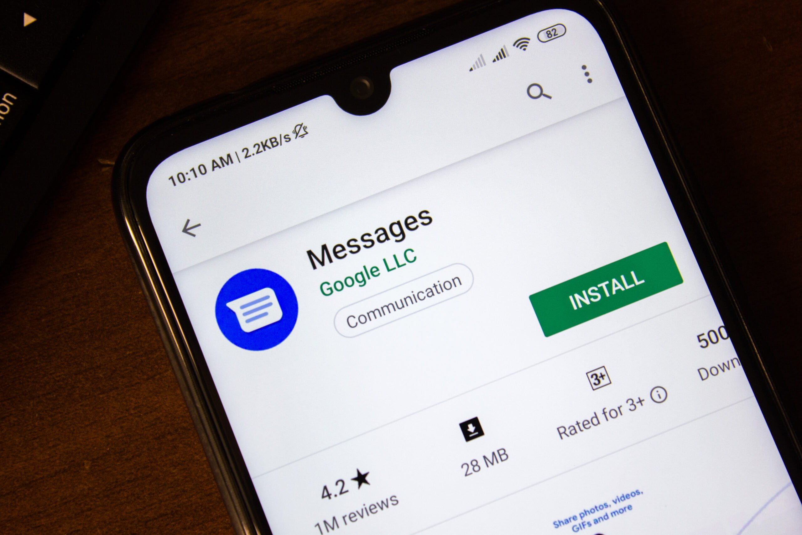 Smartfon z wyświetlonym ekranem sklepu z aplikacjami przedstawiający aplikację "Messages Google LLC" do komunikacji z przyciskiem "INSTALL", oceną 4.2 gwiazdki i podpisem "1M reviews".