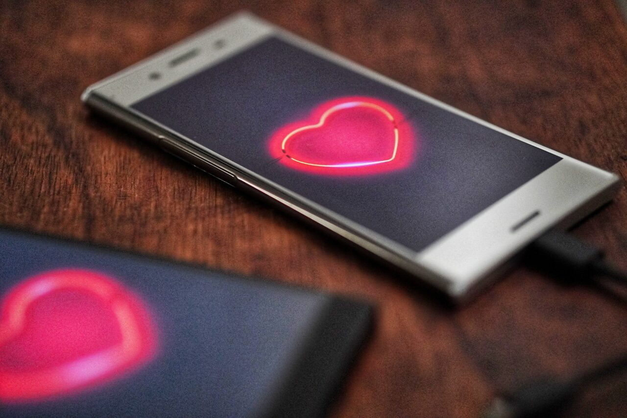 Telefon podłączony do ładowania z tapetą w kształcie serca