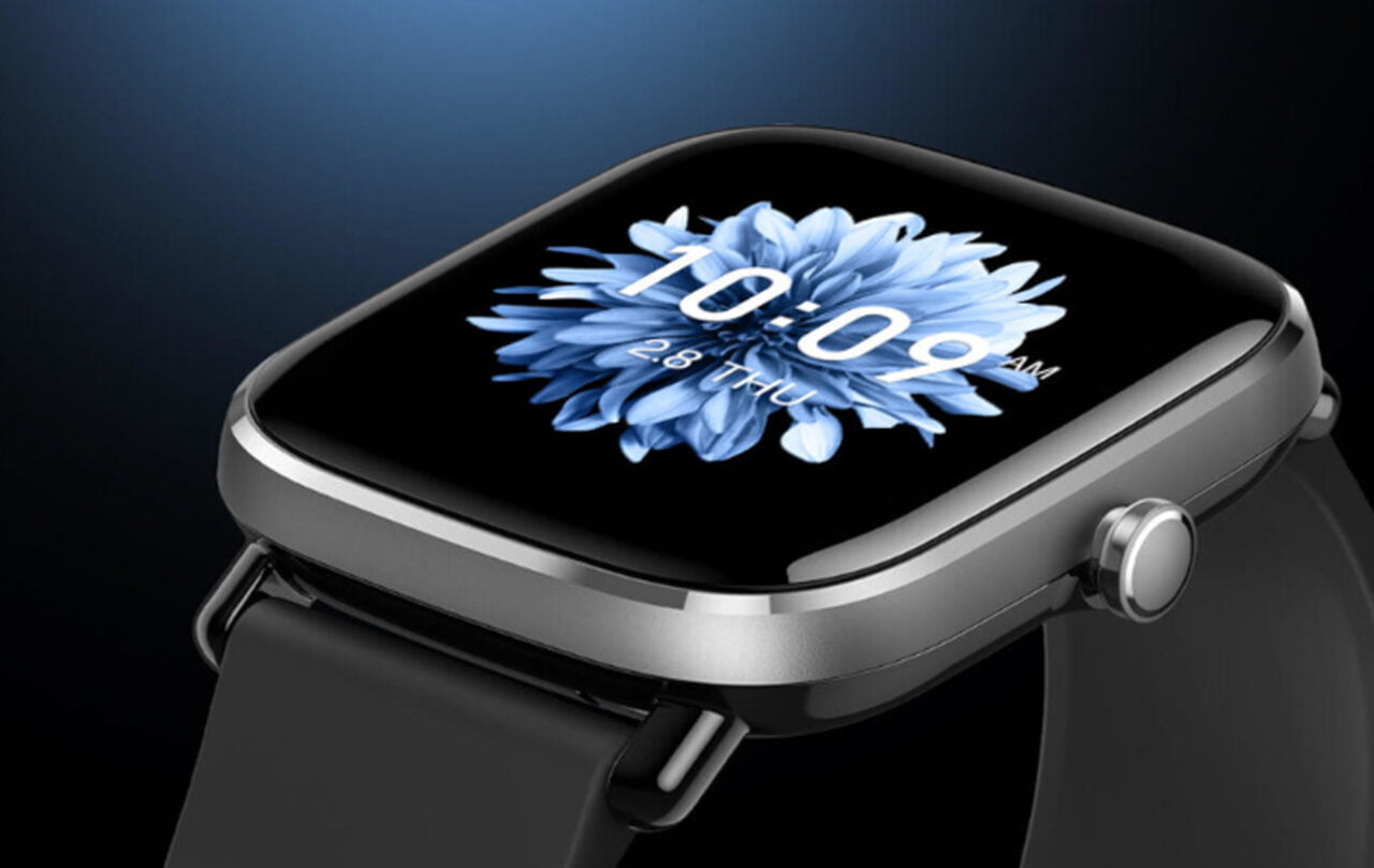 Inteligentny zegarek z kwadratową tarczą wyświetlającą niebieski kwiat i cyfrowy czas na ciemnym tle. Na zdjęciu Amazfit GTS 2 Mini - smartwatch do 300 zł