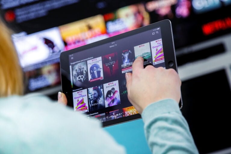 Osoba przegląda treści na tablecie z aplikacją do streamingu filmów i seriali.