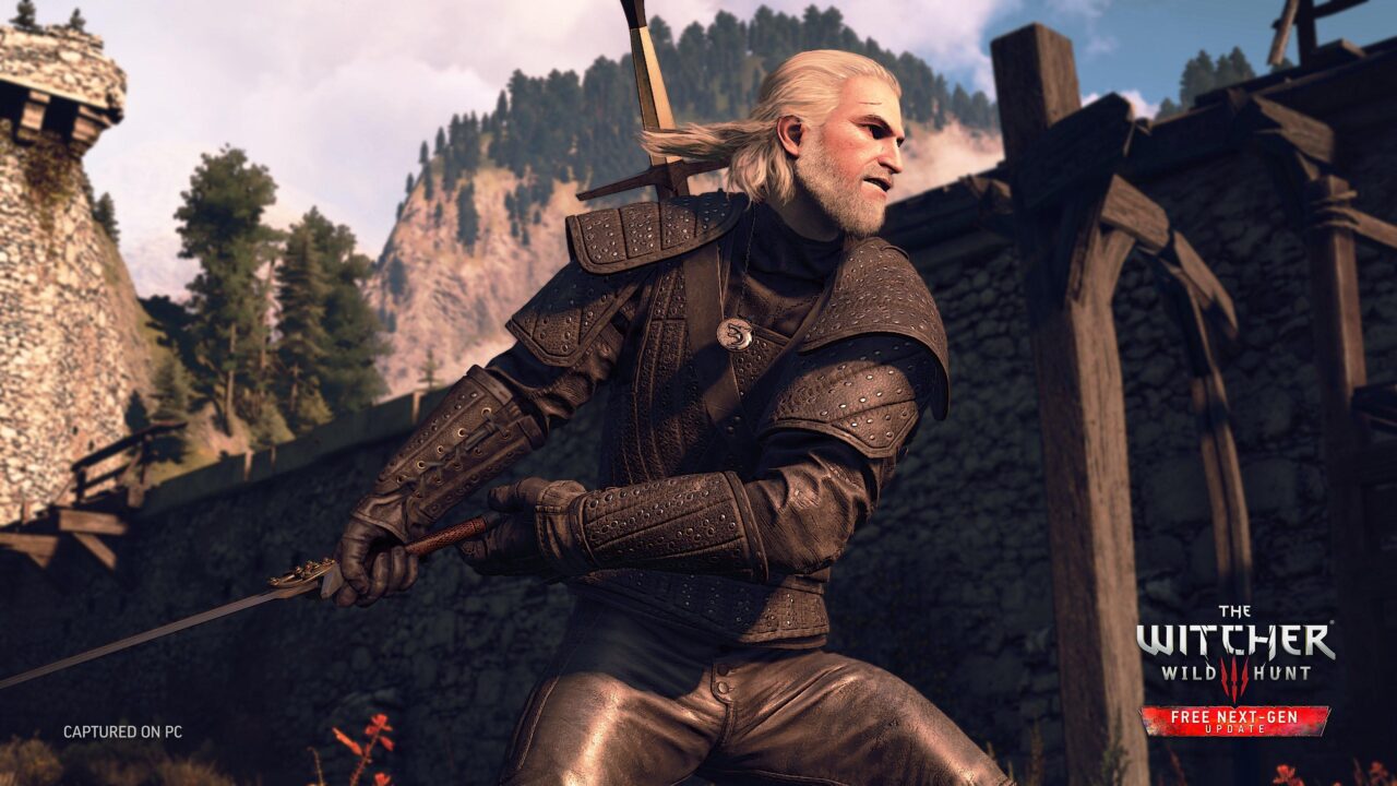 O personagem Geralt de Rivia do videogame The Witcher 3: Wild Hunt, com cabelos brancos e armadura, está com uma espada no fundo de uma fortaleza medieval e uma paisagem montanhosa. 