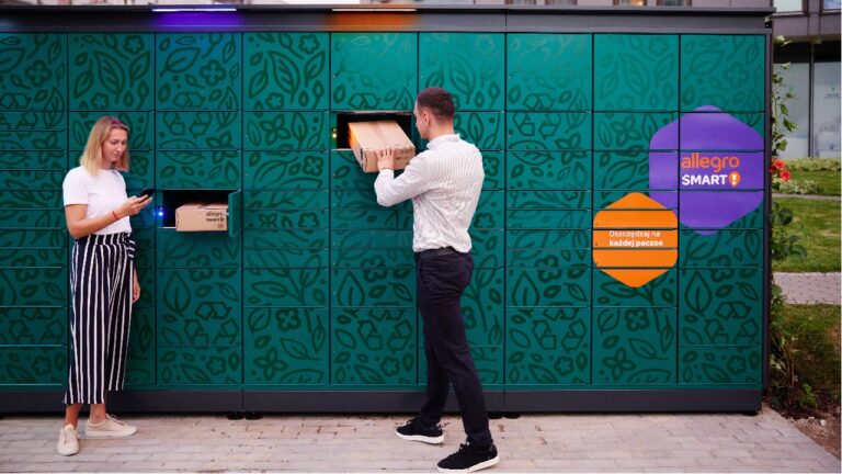 Kobieta używająca smartfonu i mężczyzna odbierający paczkę z zielonego automatu paczkowego z logo Allegro Smart.