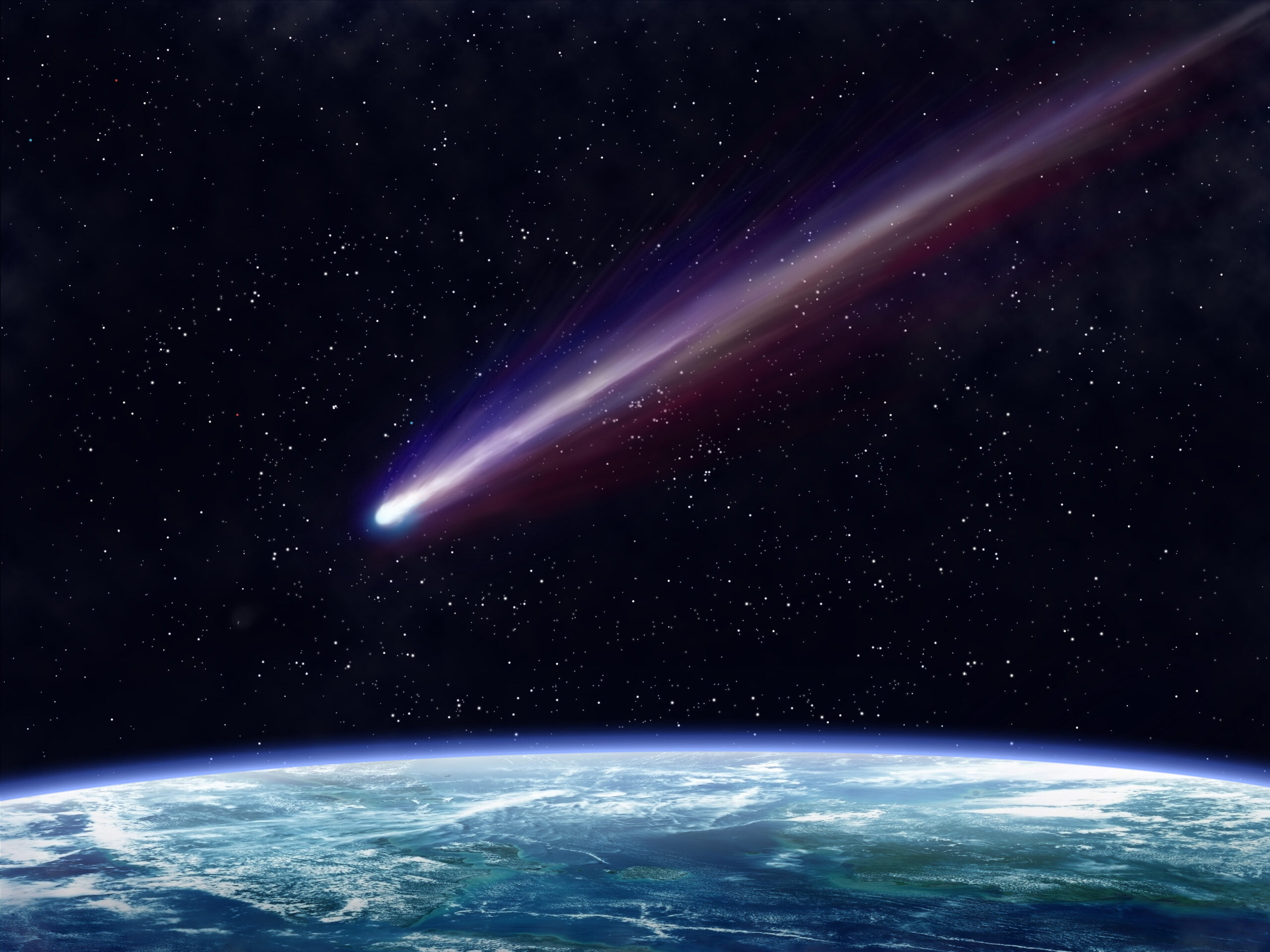 Kometa przelatująca przez ziemskie niebo nocą z wyraźnie widocznymi śladami pyłu i gazów zostawionymi na tle gwiaździstym nad błękitnym krawędzią Ziemi.
