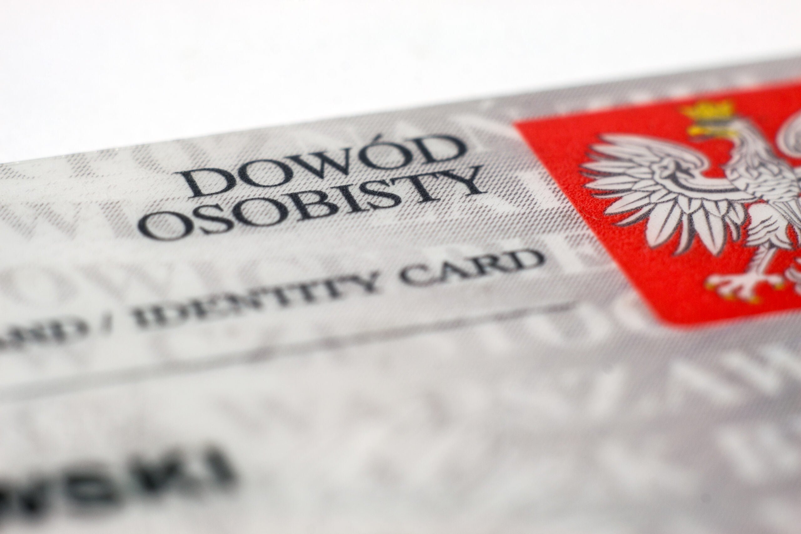 Fragment polskiego dowodu osobistego z wypukłym napisem "DOWÓD OSOBISTY" oraz orłem w koronie na czerwonym tle, symbolizującym godło Polski.