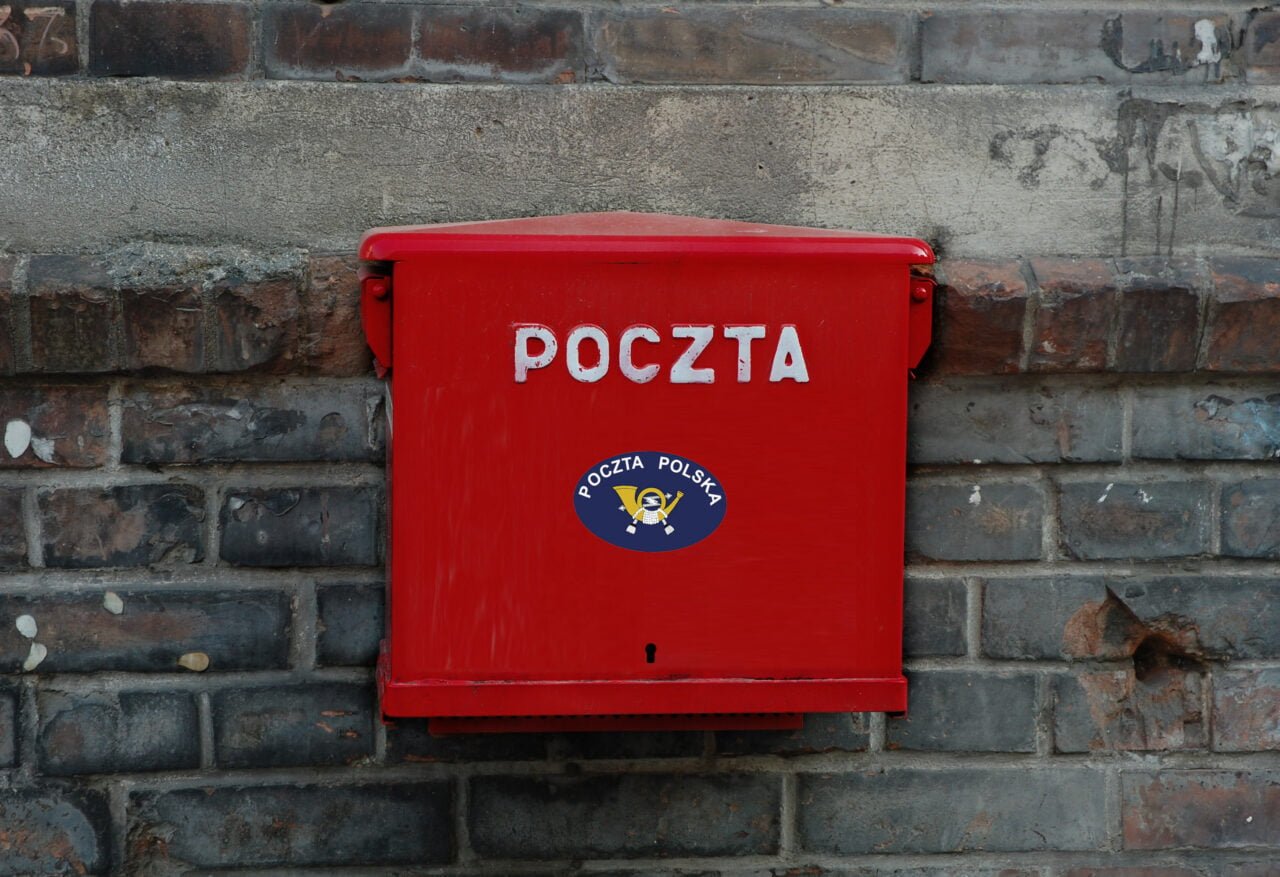 Ilustracja do artykułu o pracy jako kontroler abonamentu RTV w Poczcie Polskiej. Czerwona skrzynka pocztowa z napisem "POCZTA" i logotypem Poczta Polska na kamiennym murze.
