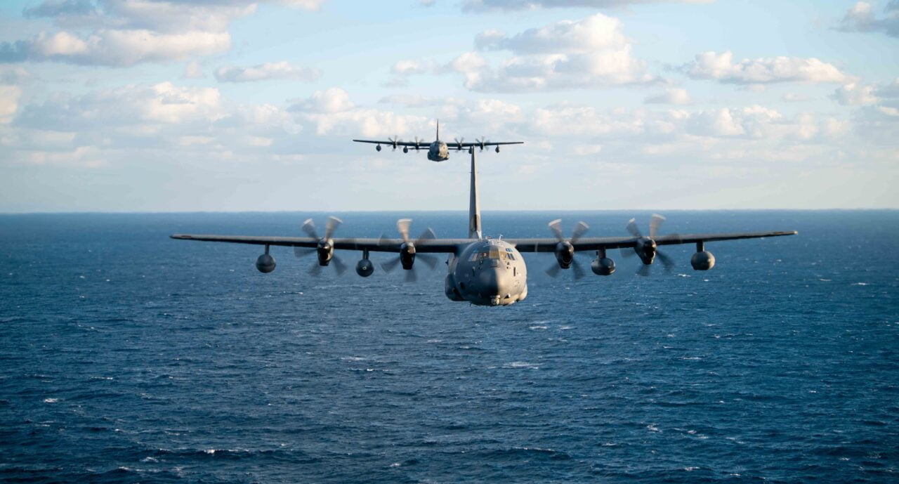 Samolot wojskowy C-130 Hercules leci nisko nad powierzchnią morza.