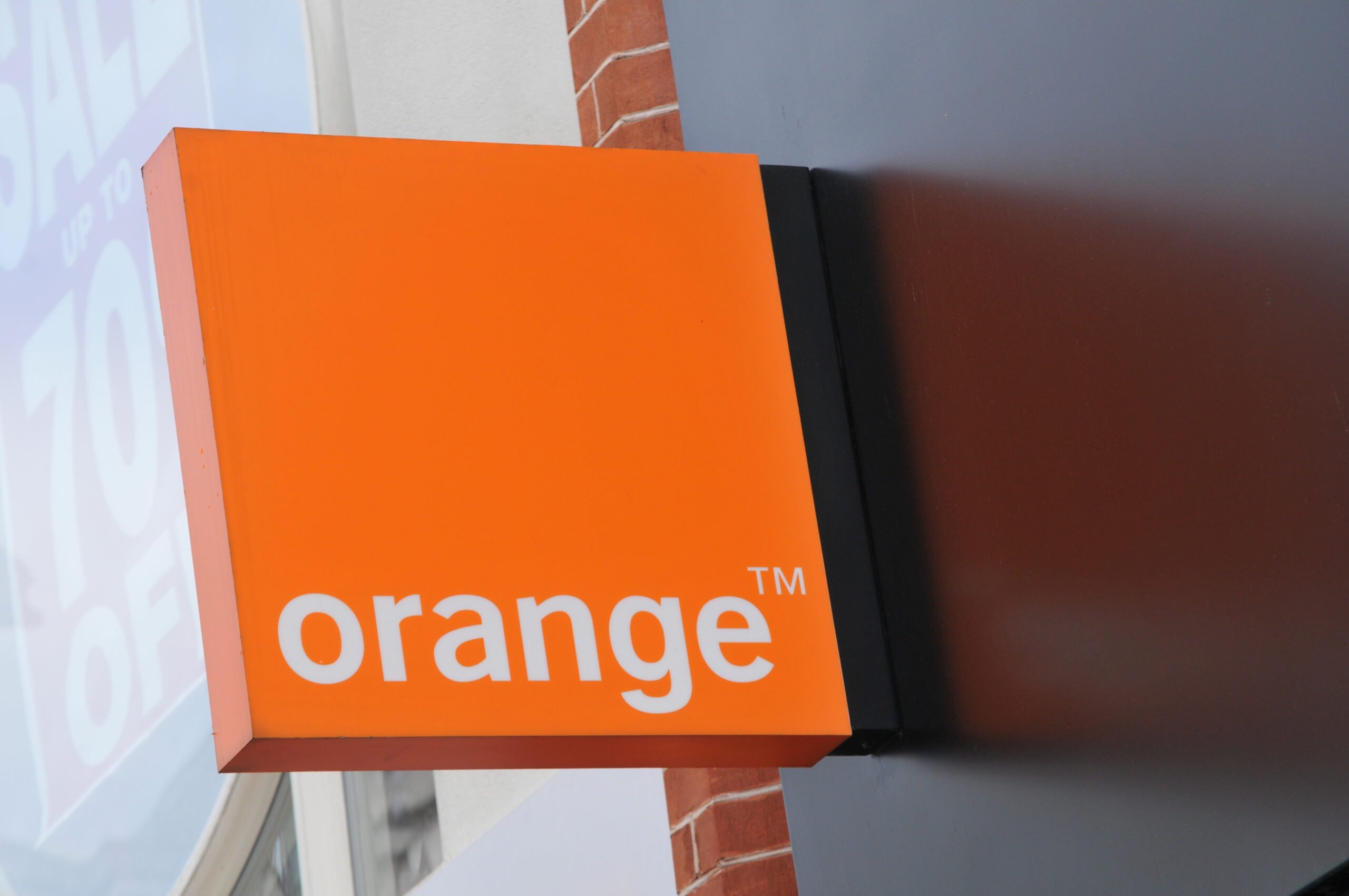 Pomarańczowe logo firmy "orange" jako szyld sklepu