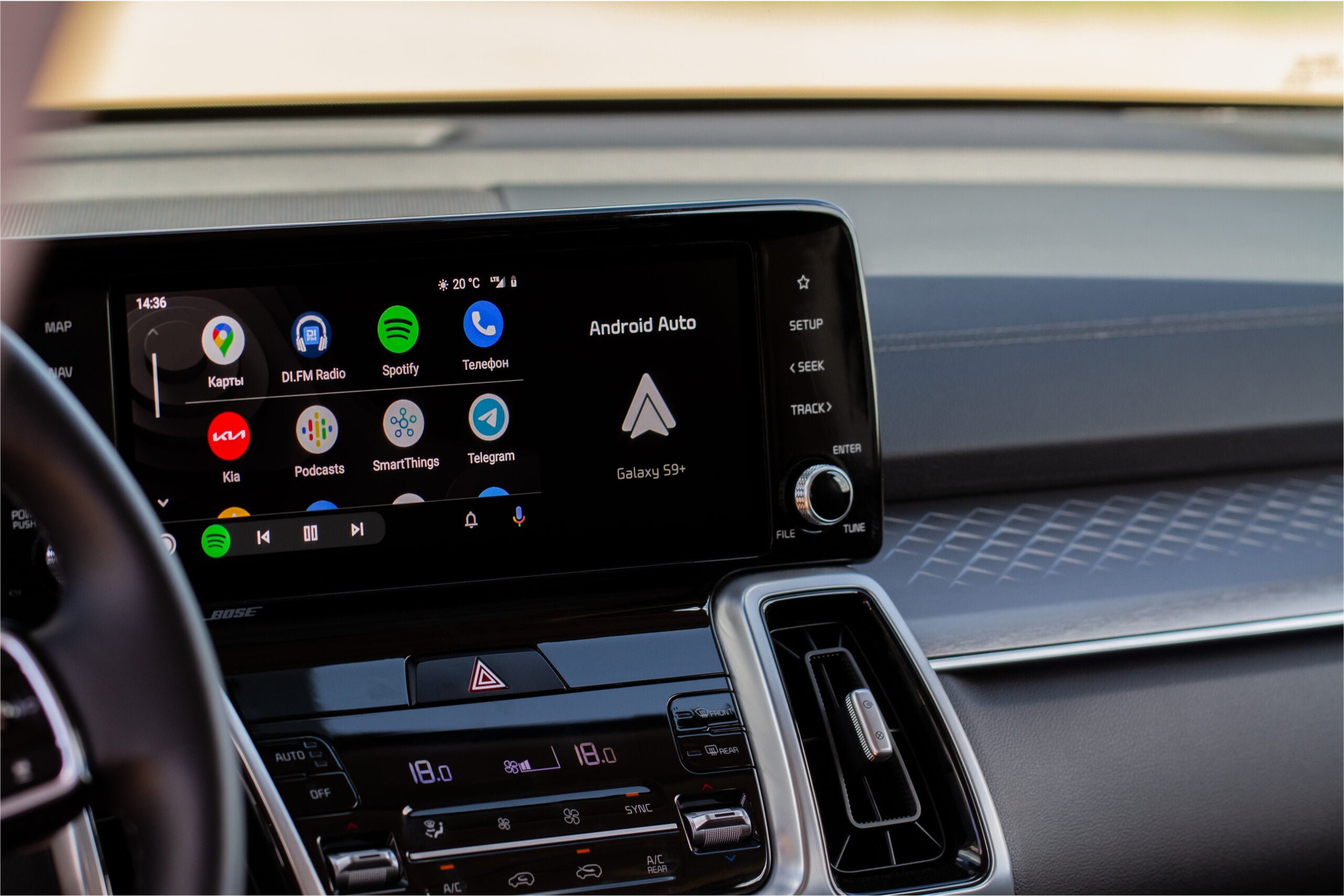 Wyświetlacz systemu multimedialnego w samochodzie z otwartą aplikacją Android Auto pokazującą ikony aplikacji takich jak Mapy, Spotify oraz wiadomości.