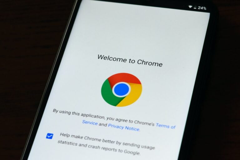 Smartfon wyświetlający ekran powitalny aplikacji przeglądarki Google Chrome z logo i tekstem "Witamy w Chrome" na ciemnym tle.