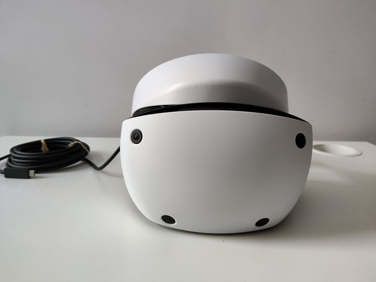 Gogle PlayStation VR2 na białym blacie, na tle białej ściany