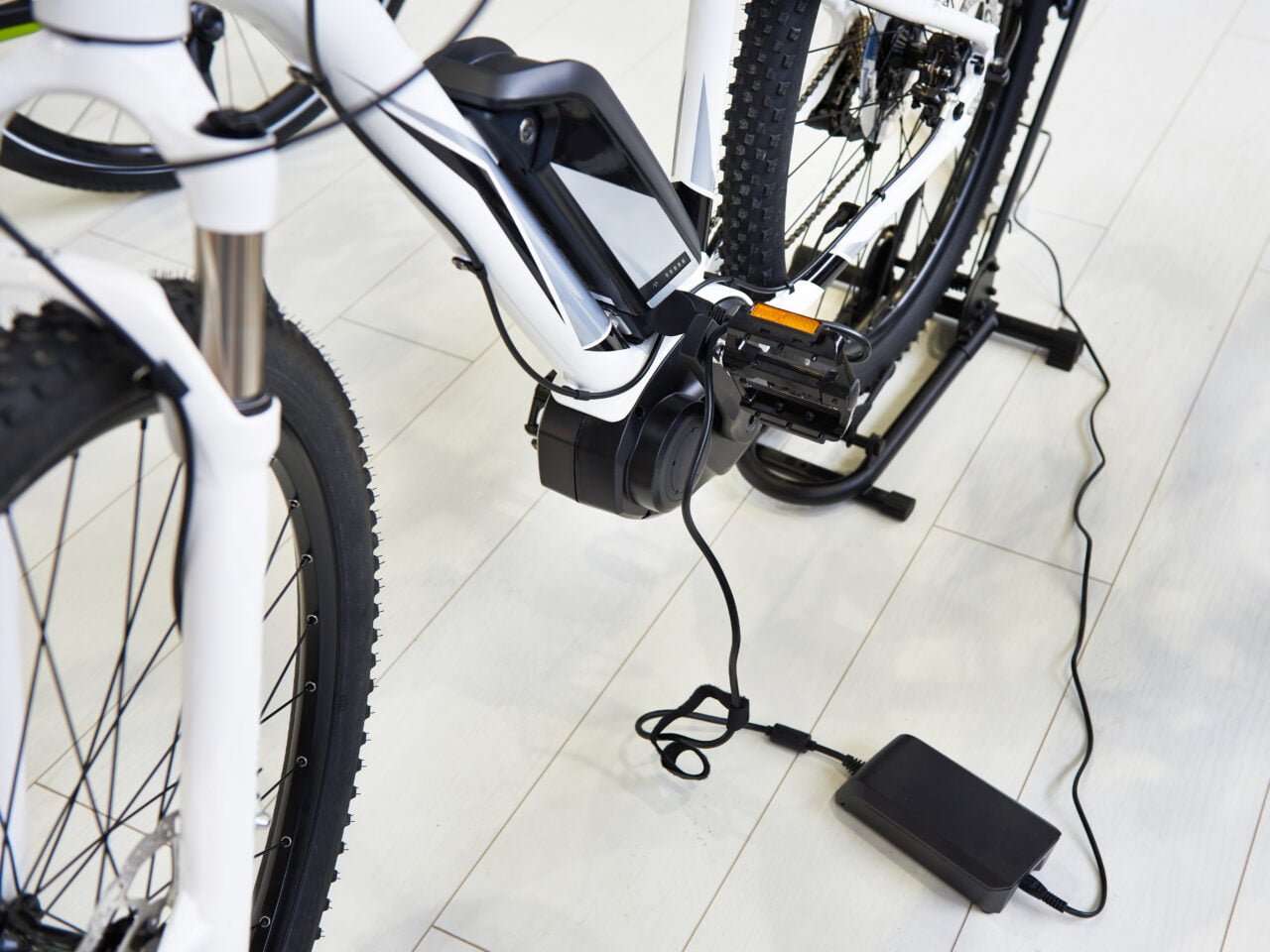 Dofinansowanie na rowery elektryczne Rower elektryczny na stojaku, podłączony do ładowarki.
