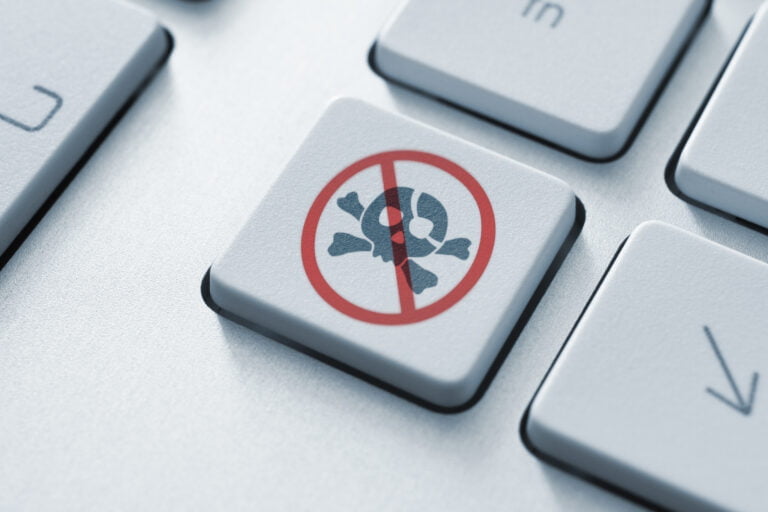 Klawisz na klawiaturze komputerowej z czerwonym symbolem prohibicji pokrywającym ikonę pirackiej czaszki.
