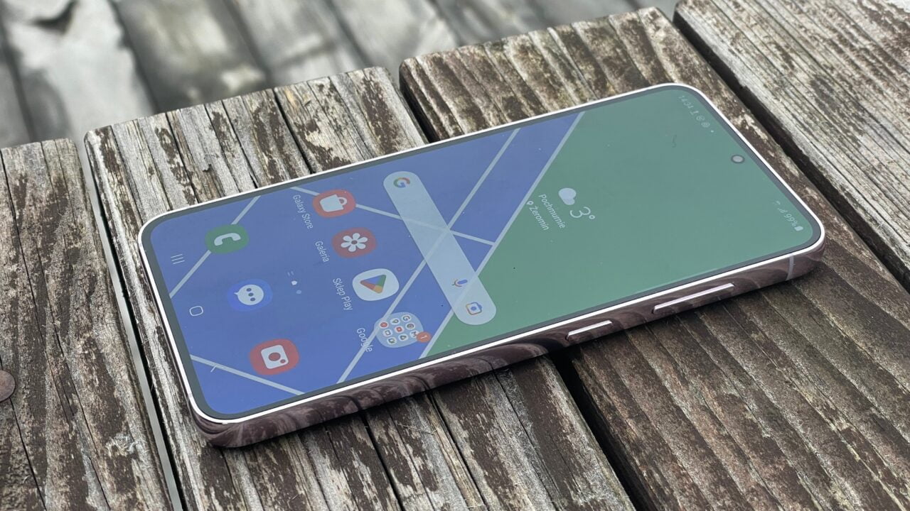 ceny używanych smartfonów - galaxy s23 leżący na szarej, drewnianej ławce z widocznym ekranem głównym interfejsu użytkownika.