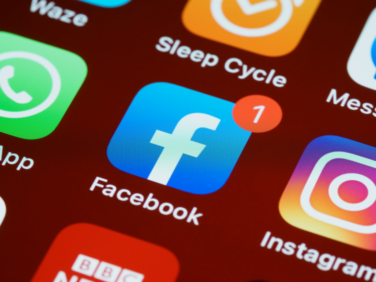 Ikona aplikacji Facebook z powiadomieniem na ekranie smartfona, otoczona innymi ikonami aplikacji. Polacy nie chcą płacić za ich subskrypcje.
