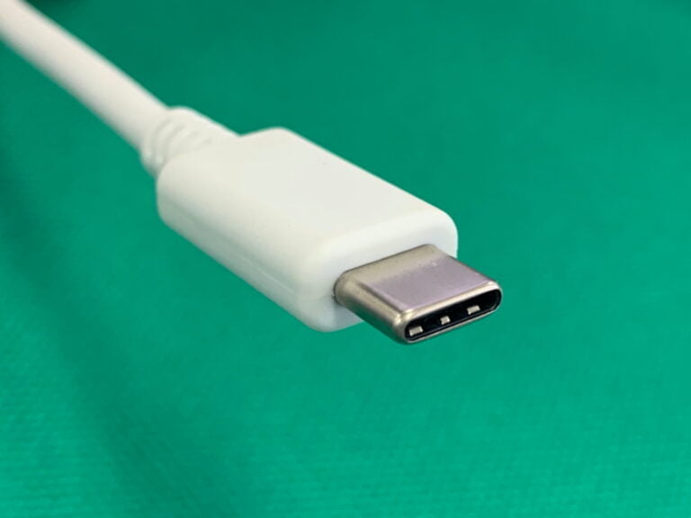 Biały kabel USB-C na zielonym tle.