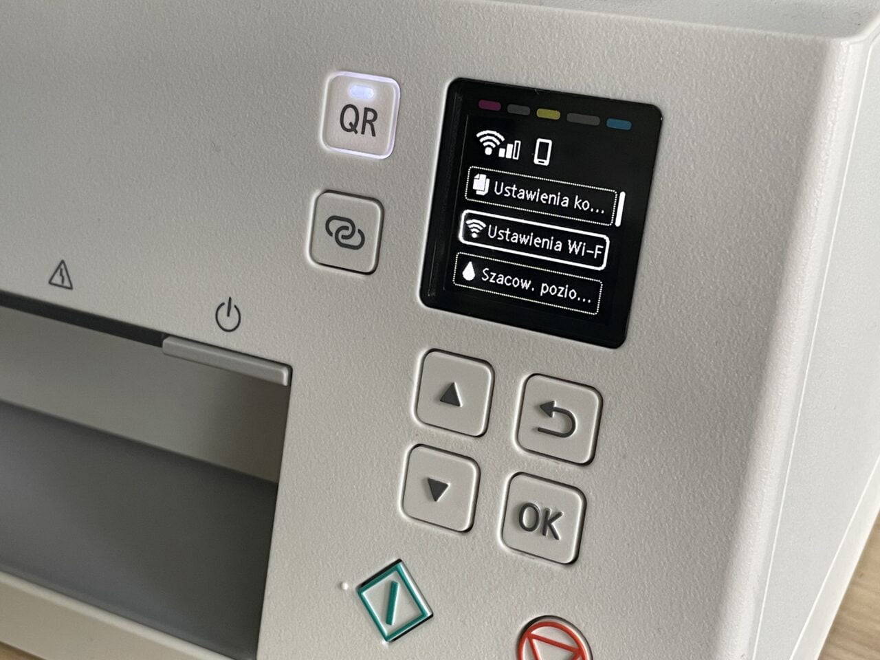 Panel sterowania urządzenia z kolorowym ekranem LCD wyświetlającym opcje menu w języku polskim, przyciski nawigacyjne oraz symbol QR. Jak zainstalować drukarkę Canon na przykładzie modelu Canon PIXma TS6351
