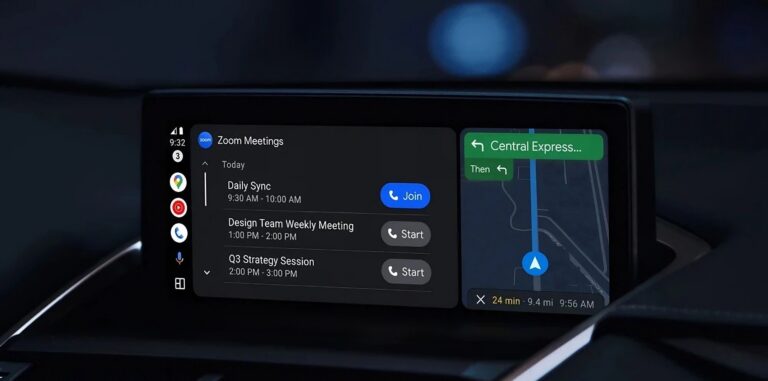 Wyświetlacz systemu informacyjno-rozrywkowego Android Auto w samochodzie prezentujący ekran podzielony na aplikację Zoom Meetings z listą spotkań i możliwością dołączenia do nich oraz aplikację nawigacji z wyświetloną trasą i szacowanym czasem dojazdu.