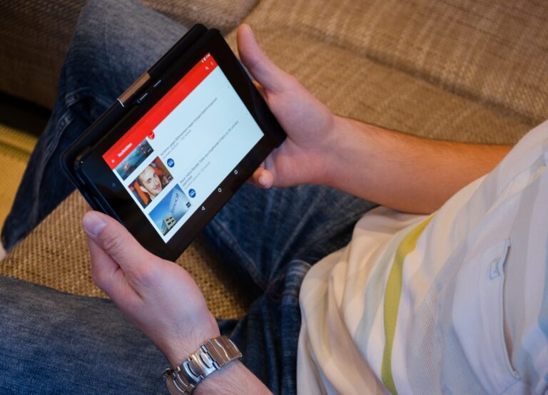 Osoba trzymająca tablet, oglądająca materiały na YouTube.