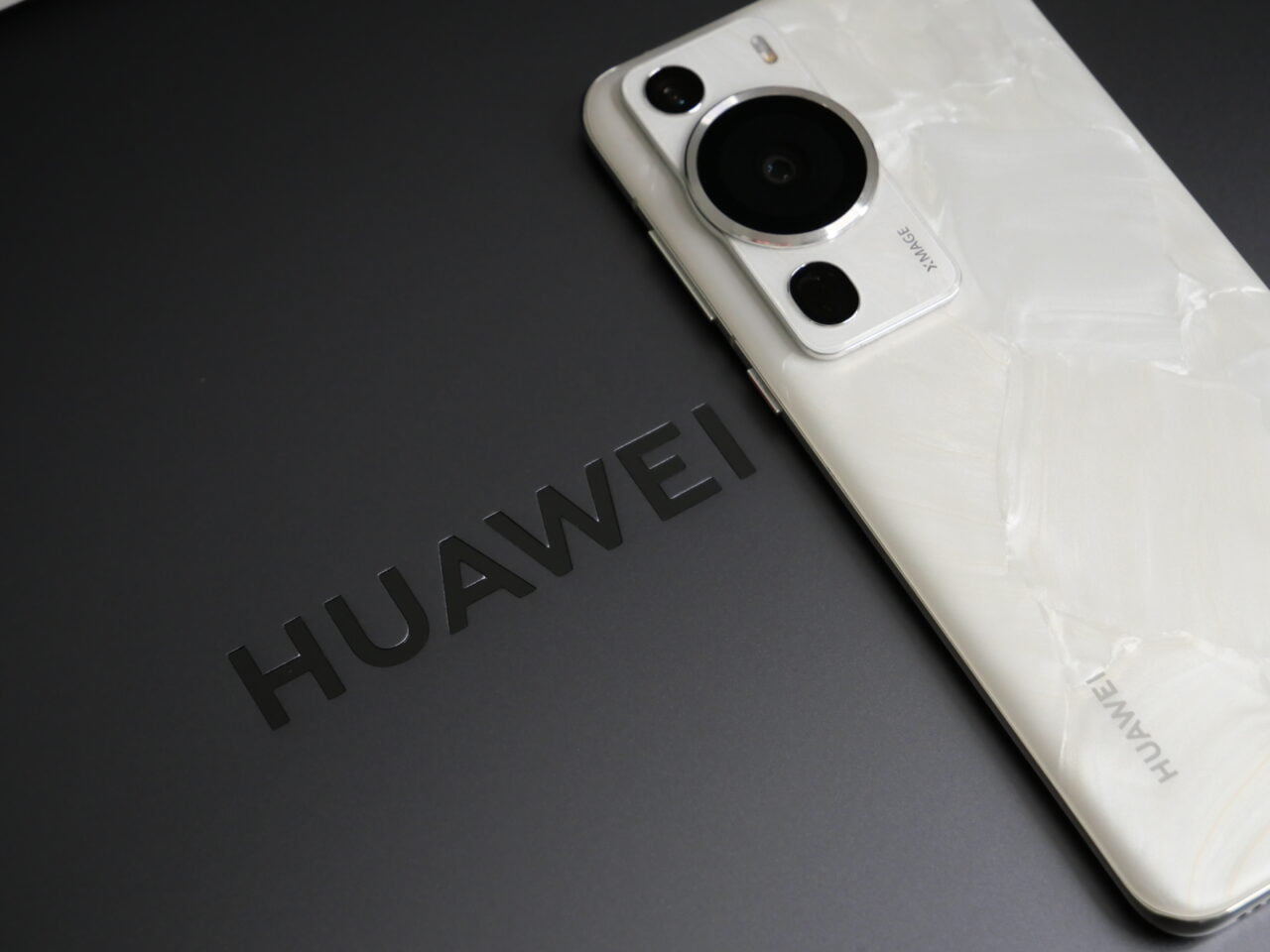 Biały smartfon HUAWEI P60 Pro leżący na laptopie HUAWEI