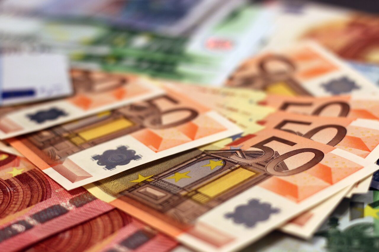 Nierozmienione banknoty euro o różnych nominałach rozłożone na płasko.