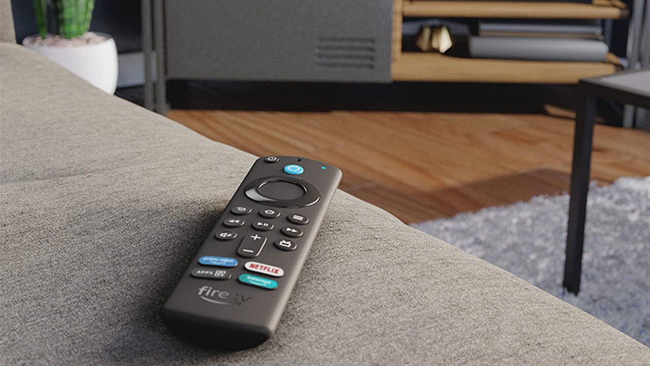 Um controle remoto da Fire TV TV deitado em um sofá cinza em uma moderna sala de estar.