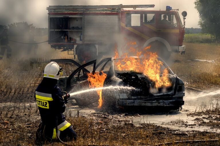 Strażak pracujący przy pożarze samochodu elektrycznego