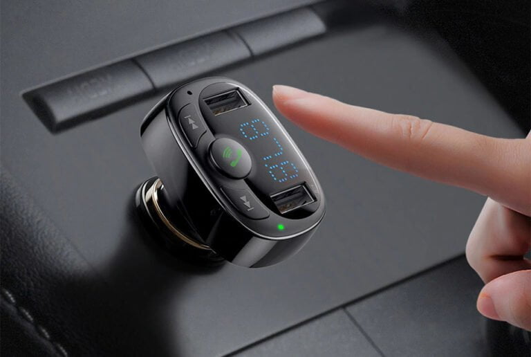 Transmiter FM w samochodzie z cyfrowym wyświetlaczem i ręką osoby naciskającej przycisk.