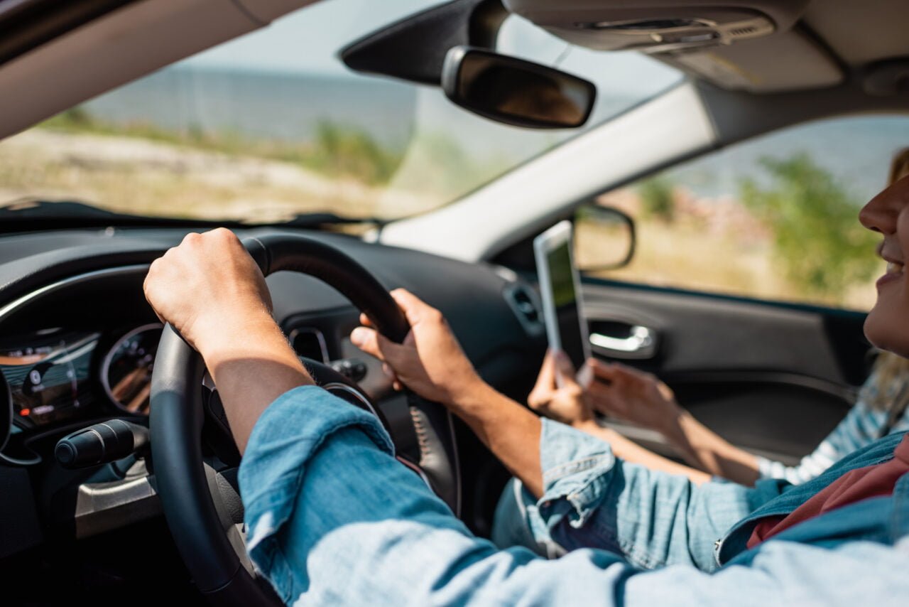 Zdjęcie poglądowe do tematu o tym, jak wygląda aktualizacja Android Auto 11.4 - kobieta prowadząca samochód, widok z perspektywy pasażera, skupia się na drodze.