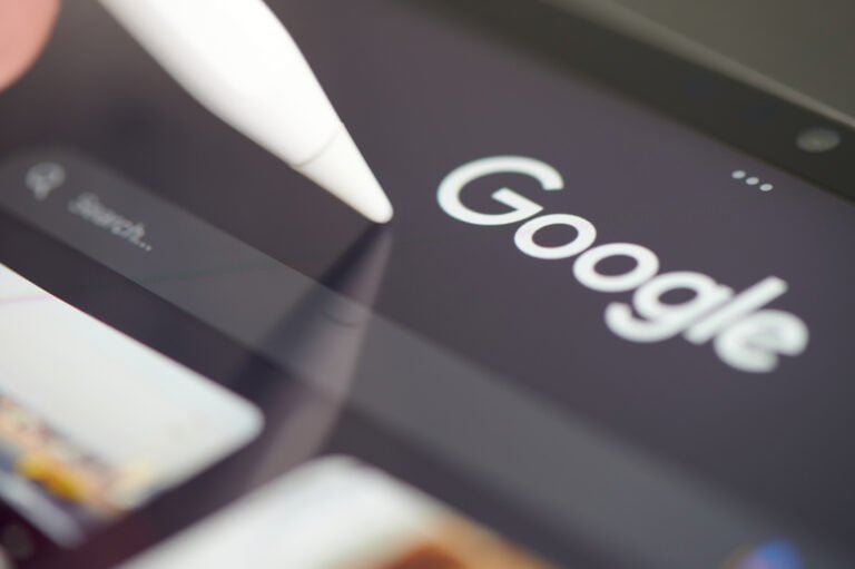 Logo Google na ekranie tabletu, na którym znajduje się biała rysik, zdjęcie z niewielkim zogniskowaniem.