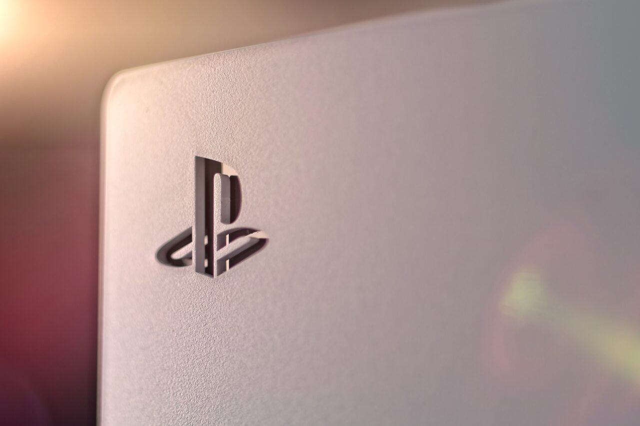 Logo PlayStation na białej powierzchni z efektem świetlnym w tle.