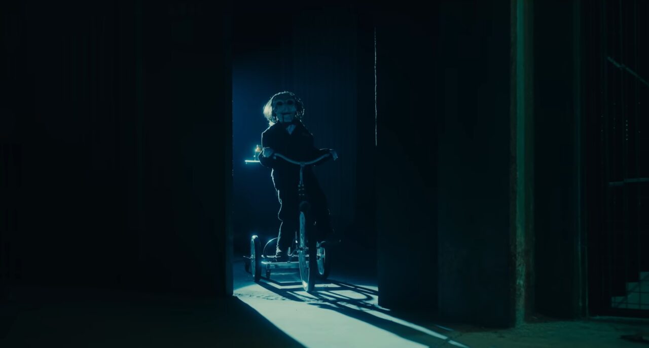 Osoba na hulajnodze elektrycznej stoi w mrocznym przejściu z jasnym światłem w tle.