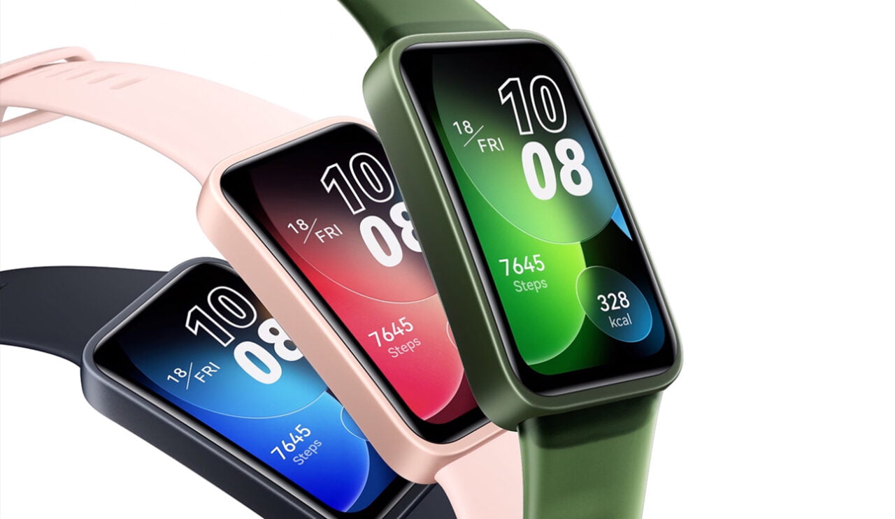 Trzy inteligentne zegarki z ekranami dotykowymi pokazujące różne tarcze z informacjami o czasie, liczbie kroków i spalonych kaloriach, umieszczone obok siebie, każdy z innym kolorem paska.