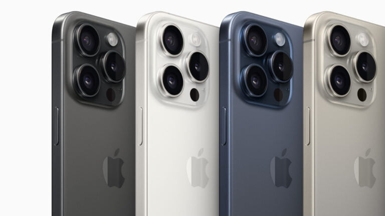 Cztery smartfony iPhone ułożone obok siebie tylnymi panelami do przodu, każdy z potrójnym układem aparatów fotograficznych i logo firmy. Kolorystyka od ciemnoszarego, poprzez biały i niebieski, do złotego.
