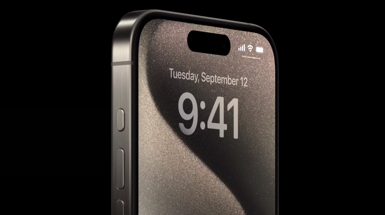 Czarny smartfon z włączonym ekranem pokazującym blokadę ekranu z godziną 9:41 i datą "Wtorek, wrzesień 12", na tle czarnym.