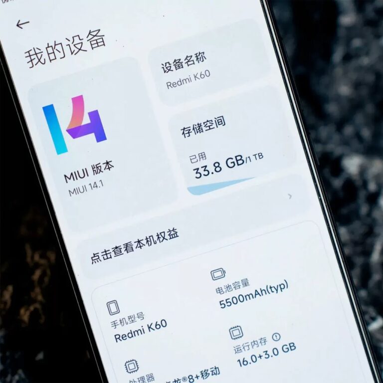 Smartfon wyświetlający ustawienia z informacjami o urządzeniu Redmi K60, wersji oprogramowania MIUI 14.1 oraz dostępnej pamięci i pojemności baterii, wszystko opisane w języku chińskim.